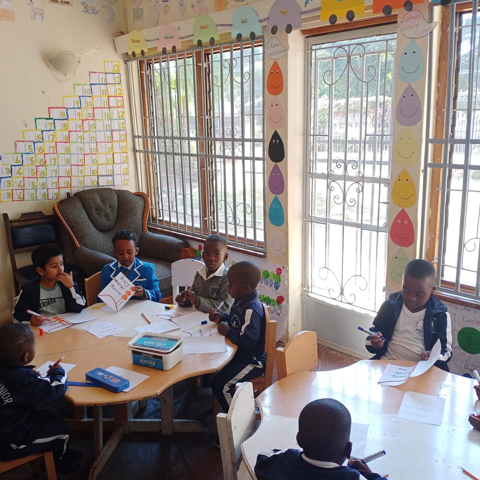 Junior school pupils in blazers writing at their tables in a bright classroom at Nirmeen, Belvedere